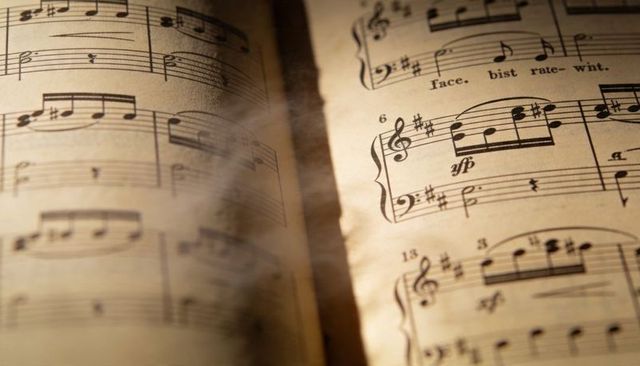 Vintage sheet music spread glowing under warm light with treble clef and aged parchment