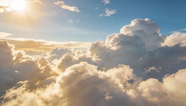 Sunlit towering cumulonimbus cloudscape at golden hour with dramatic blue sky and sunbeams