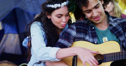 Young Couple Enjoying Guitar Session at Camp Site