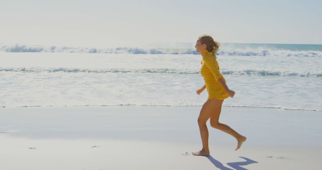 A young Caucasian girl is joyfully running along the shoreline on a sunny beach day, with copy space. Her carefree sprint against the backdrop of rolling waves captures the essence of summer fun and freedom.