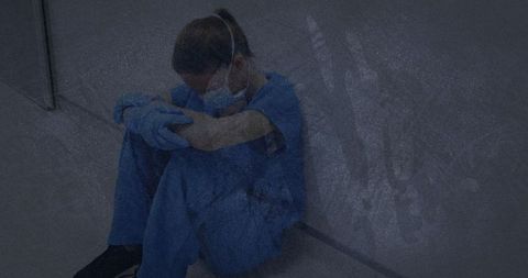 Exhausted healthcare worker sitting on hospital floor