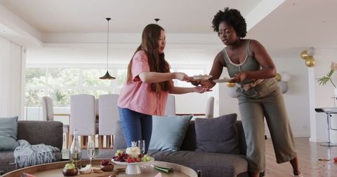 Friends Cleaning Up After Birthday Party Celebration at Home