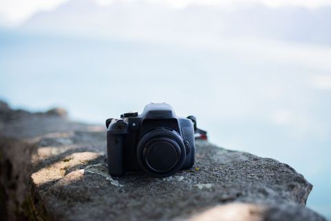 Technology dslr camera outdoors on stone wall with blurred background