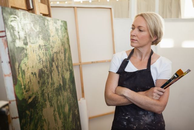 Woman standing with arms crossed in drawing class