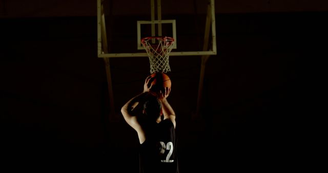 Basketball Player Shooting Ball at Hoop in Low Light - Download Free Stock Images Pikwizard.com