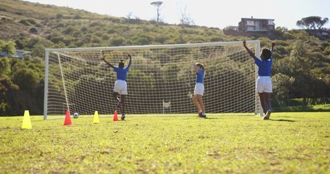 Girls Soccer Team Celebrating Goal on School Field
