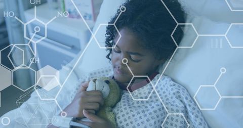 Child in Hospital Gown Holding Stuffed Animal with Molecular Background