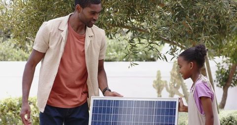 Father and daughter learning about solar energy in garden