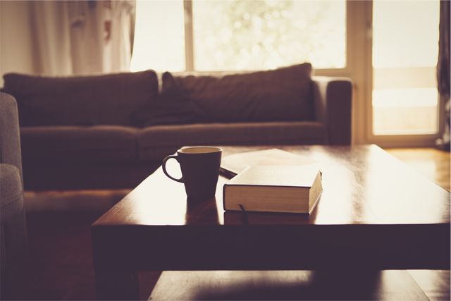 Cozy Living Room with Coffee Mug and Book on Wooden Coffee Table - Download Free Stock Photos Pikwizard.com