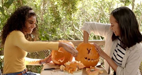 Friends Enjoying Pumpkin Carving Together Outdoors