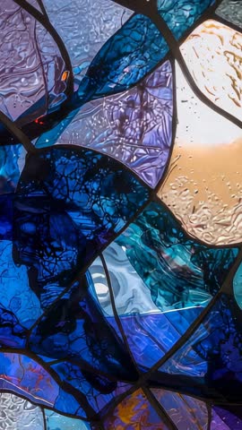 Vertical Video Capturing Backlit Stained Glass Mosaic Drifting with Warm Iridescent Glow