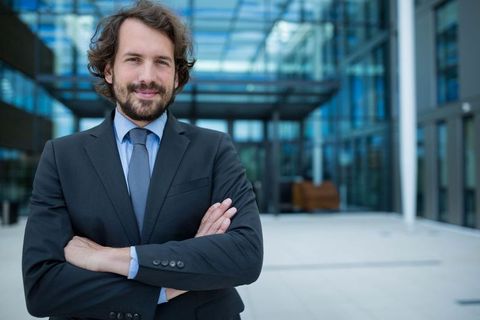 Confident business consultant standing outside modern office building