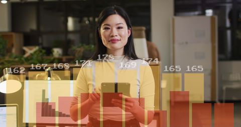 Asian Businesswoman Analyzing Financial Data with Digital Bar Graph