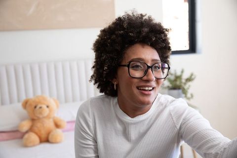 Joyful woman relaxing at home, connecting with comfort