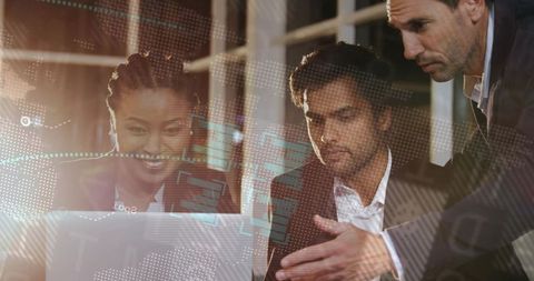 Business team collaborating over laptop with digital analytics overlays in modern office