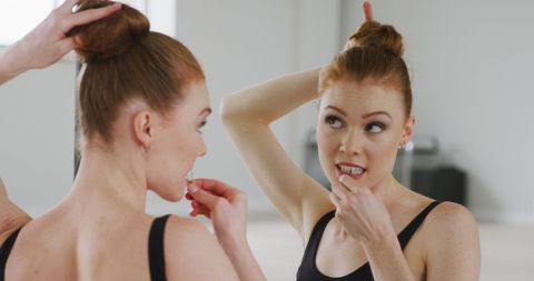 Ballet Dancer Preparing Hair in Mirror Reflection