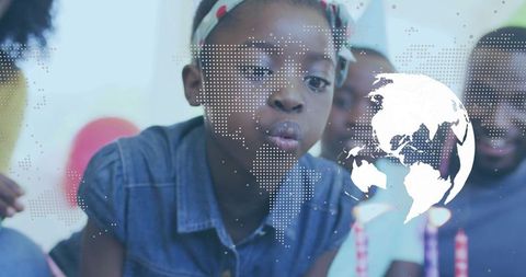 Joyful Child Blowing Birthday Candles with World Map Overlay