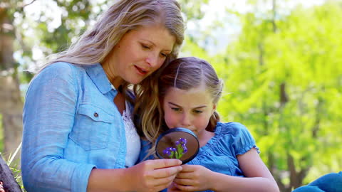Mother and Daughter Exploring Nature with Magnifying Glass