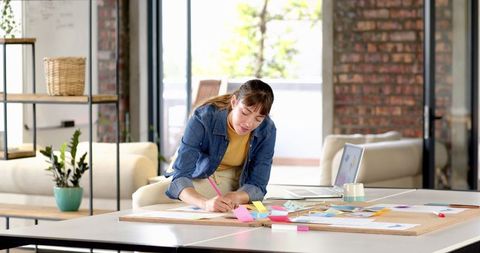 Woman writing notes in modern loft home office