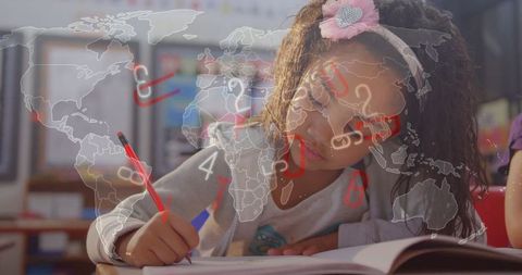 Young schoolgirl writing at desk with world map overlay