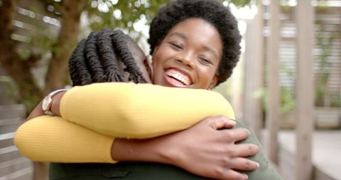 Joyful Hugging with Friends in Sunlit Garden Walkway