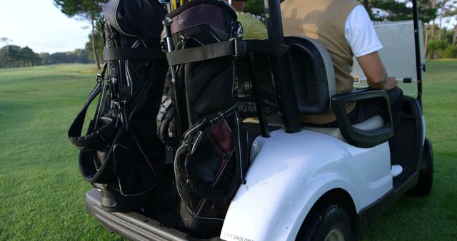 Two golfers driving in their golf buggy at golf course