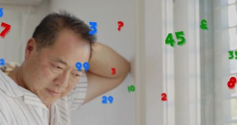 Mature man leaning by window with colorful numeric overlay contemplating memory and data