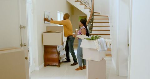 Couple arranging pictures during move into new home