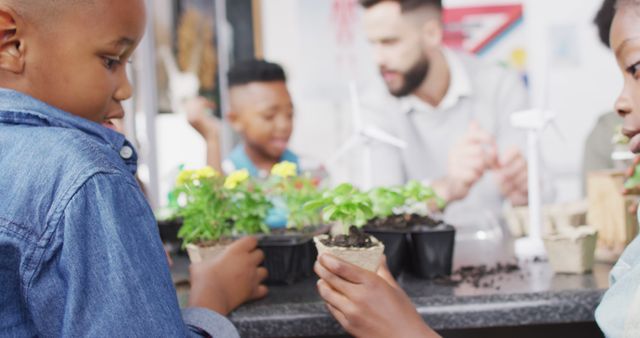 Children engaging in hands-on learning about plants in a science classroom with their teacher. Ideal for use in educational materials, school brochures, websites promoting science education, environmental awareness campaigns, and interactive learning resources.