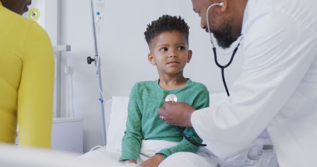 Doctor checking young boy with stethoscope in hospital room. Ideal for healthcare, medical services, pediatric care, treatment of illnesses and family healthcare services.