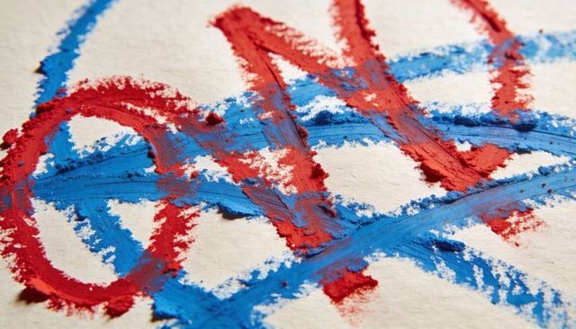 Crushed red and blue pastel loops creating bold textured strokes on rough paper