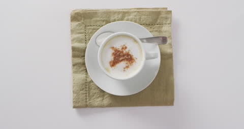 Aromatic Cappuccino Foam with Cinnamon on Beige Napkin