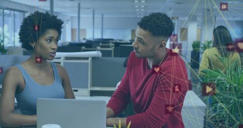 Colleagues collaborating with technology icons in modern office