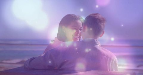 Romantic Couple Embracing by Ocean at Twilight with Dreamy Lights