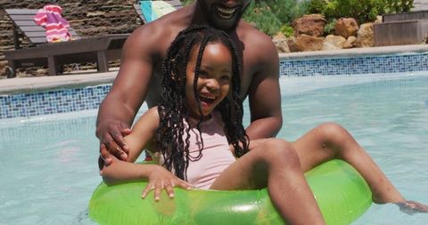 Father and Daughter Enjoying Summer in Swimming Pool