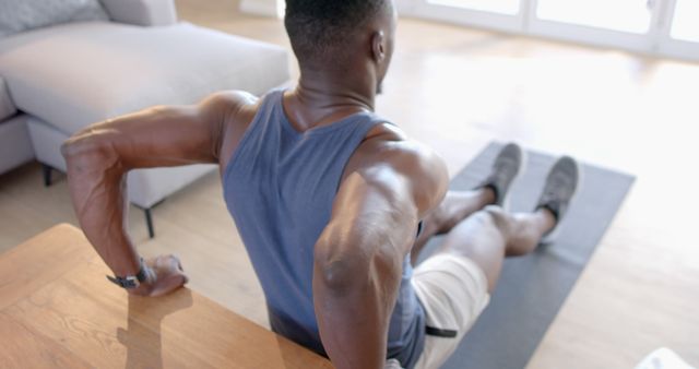 Man Exercising Indoors, Engaging in Tricep Dips for Strength Training - Download Free Stock Images Pikwizard.com