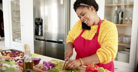 Joyful African American Woman Multitasking in Bright Kitchen