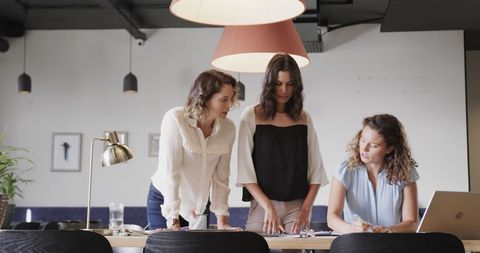 Diverse Colleagues Collaborating in Office Meeting with Laptop
