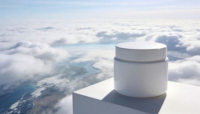 Floating minimal white cosmetic jar on pedestal above clouds luxury skincare mockup