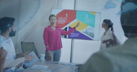 Presenter Pointing at Colorful Infographic on Screen During Team Strategy Meeting