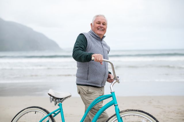 Senior man standing with bicycle on the beach - Download Free Stock Photos Pikwizard.com