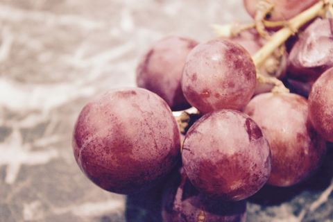 Close-up of fresh pink grapes on marble surface