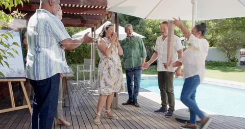 Friends Celebrating Surprise on Backyard Pool Deck — Woman Covering Face, Cheering Guests