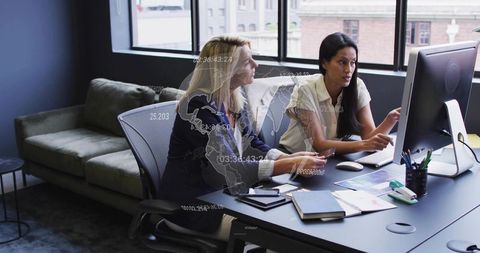Business Women Collaborating on Office Project Using Computer