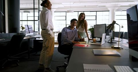 Diverse Team Collaborating at Computer Workstation in Modern Office