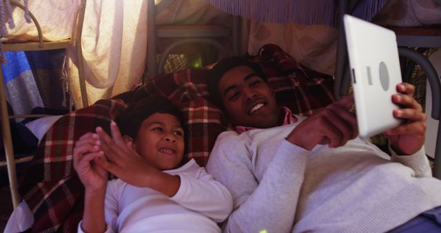 Father and Son Using Tablet in Cozy Blanket Fort - Download Free Stock Images Pikwizard.com