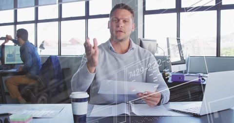 Manager gesturing while presenting reports and analytics in modern open-plan office