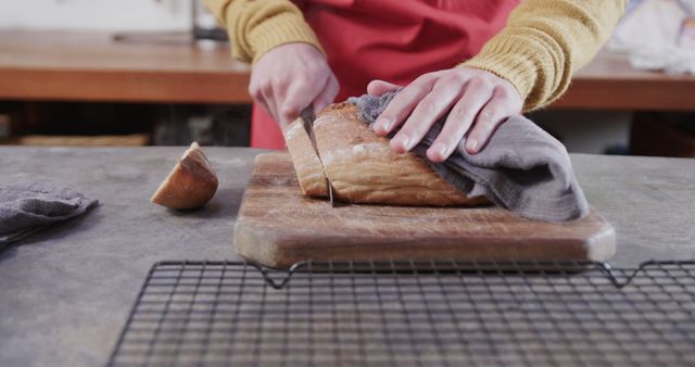 Person Slicing Fresh Homemade Bread on Cutting Board in Kitchen - Download Free Stock Images Pikwizard.com