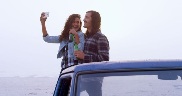 Happy Couple Taking Selfie by the Beach, Enjoying Bottled Drink - Download Free Stock Images Pikwizard.com