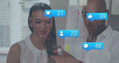 Business team collaborating on smartphone and glass wall with social media engagement icons